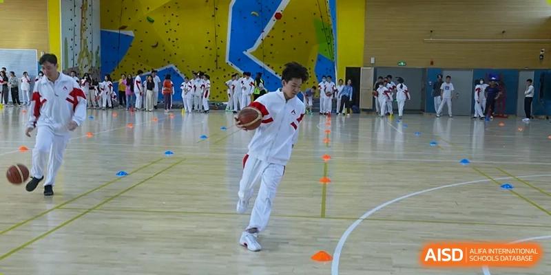 A male student from The High School Affiliated to Renmin University of China, Tongzhou Campus, plays with a basketball in a gymnasium.