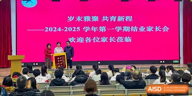 Students and faculty from The High School Affiliated to Renmin University of China, Tongzhou Campus, attend a large school event indoors.