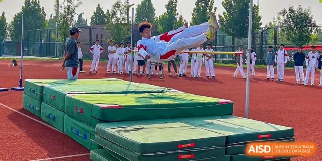 A student from The High School Affiliated to Renmin University of China, Tongzhou Campus, performs a high kick during a martial arts demonstration.