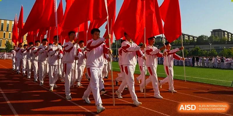 A large group of students from The High School Affiliated to Renmin University of China, Tongzhou Campus, marches outdoors in a coordinated activity.
