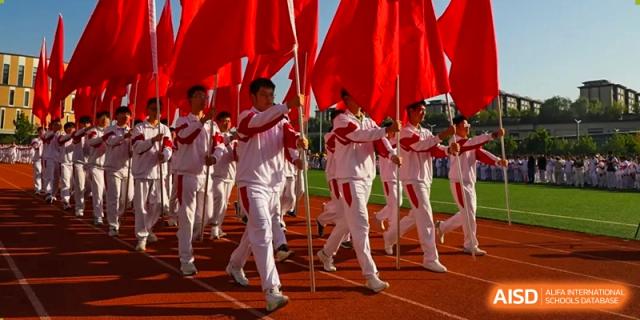 A large group of students from The High School Affiliated to Renmin University of China, Tongzhou Campus, marches outdoors in a coordinated activity.