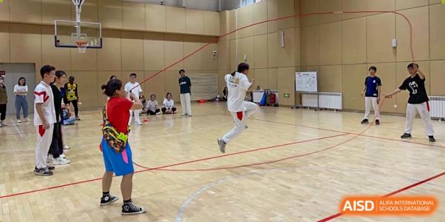 Students from The High School Affiliated to Renmin University of China, Tongzhou Campus, play a game on an indoor court.