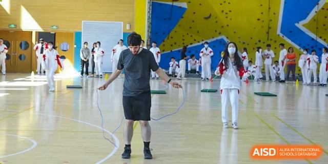 A group of students from The High School Affiliated to Renmin University of China, Tongzhou Campus, practices martial arts in a gymnasium.