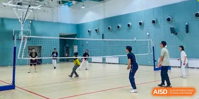 Students from The High School Affiliated to Renmin University of China, Tongzhou Campus, play volleyball in a gymnasium.