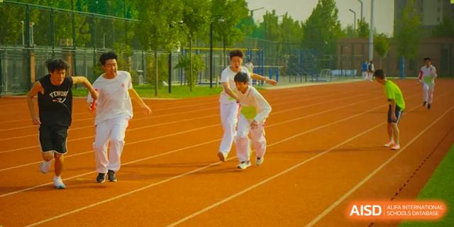 Students from The High School Affiliated to Renmin University of China, Tongzhou Campus, race on an outdoor track.