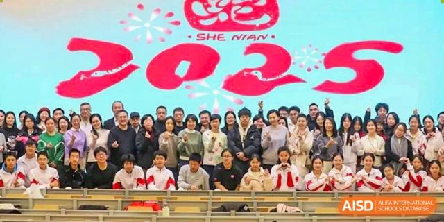 A large group of students from The High School Affiliated to Renmin University of China, Tongzhou Campus, poses for a group photo outdoors.