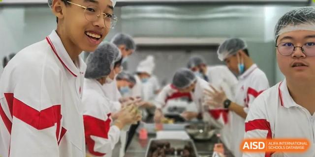 Students from The High School Affiliated to Renmin University of China, Tongzhou Campus, work together to prepare food in a kitchen.