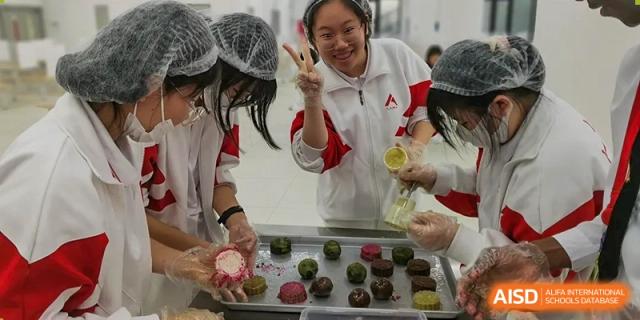 A student from The High School Affiliated to Renmin University of China, Tongzhou Campus, places a decorated mooncake on a tray.