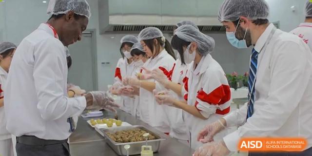 Students from The High School Affiliated to Renmin University of China, Tongzhou Campus, press food into a mold.