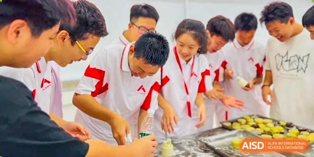 Students from The High School Affiliated to Renmin University of China, Tongzhou Campus, stand around a table and prepare mooncakes.