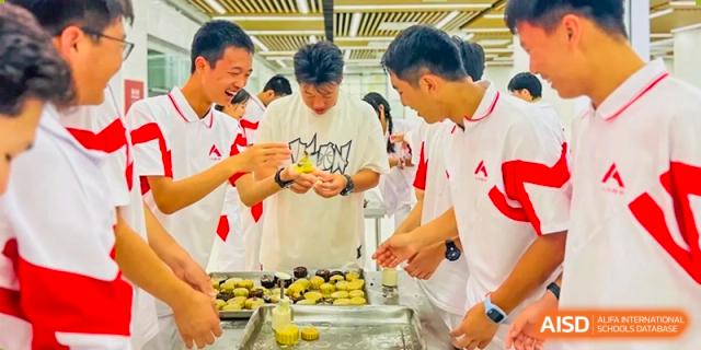 Students from The High School Affiliated to Renmin University of China, Tongzhou Campus, stand and talk while preparing food.