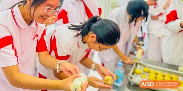 A female student from The High School Affiliated to Renmin University of China, Tongzhou Campus, carefully handles a mooncake.