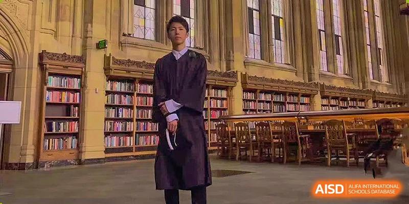 A person from Tianfu school The Integrated and Innovative Curriculum wearing a graduation gown in a library.
