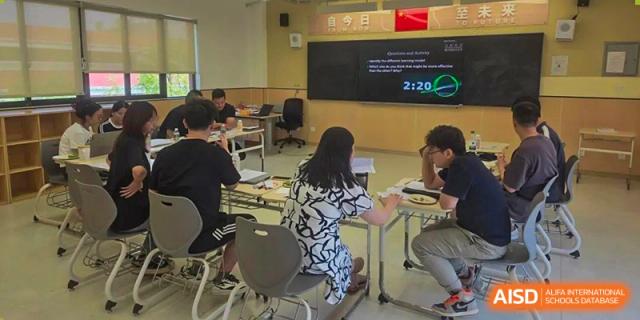 A group of students from Tianfu school The Integrated and Innovative Curriculum working on laptops in a classroom.