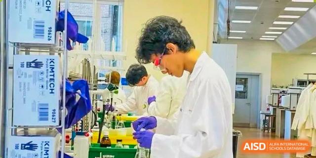 Tianfu school The Integrated and Innovative Curriculum students in lab coats and safety glasses conducting a science experiment.