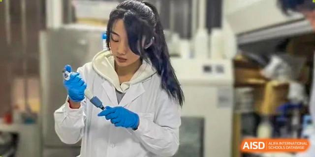 A student from Tianfu school The Integrated and Innovative Curriculum wearing a lab coat and gloves in a science lab.
