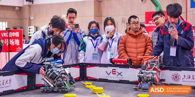 Students and teachers from Tianfu school The Integrated and Innovative Curriculum gathered around a VEX robotics display.