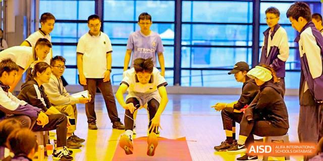A student from Tianfu school The Integrated and Innovative Curriculum participating in a jumping or racing game indoors.