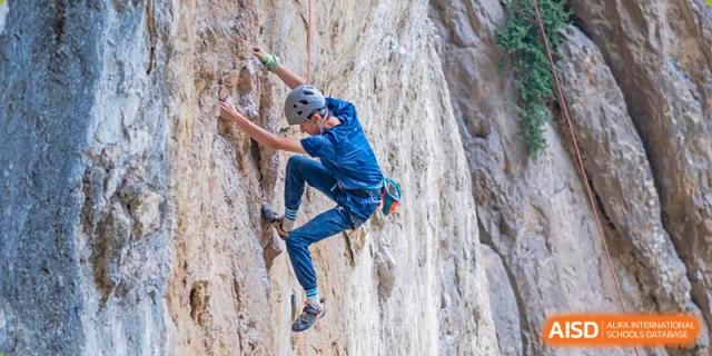 A student from Tianfu school The Integrated and Innovative Curriculum rock climbing on an outdoor wall.