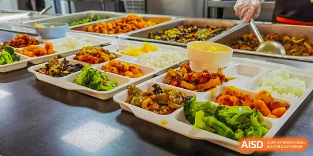 A variety of different Chinese dishes and vegetables served in trays at Tianfu school The Integrated and Innovative Curriculum.