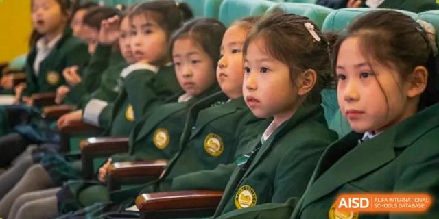 A group of students from Times College listening attentively during a school event.
