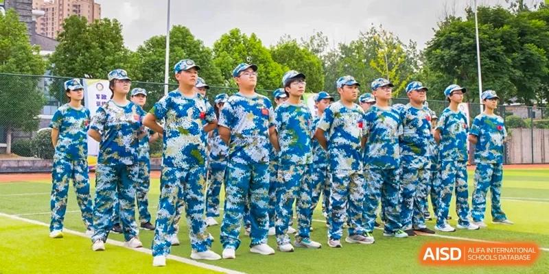 A group of students from Times College standing in formation, wearing blue and white camouflage military training uniforms.