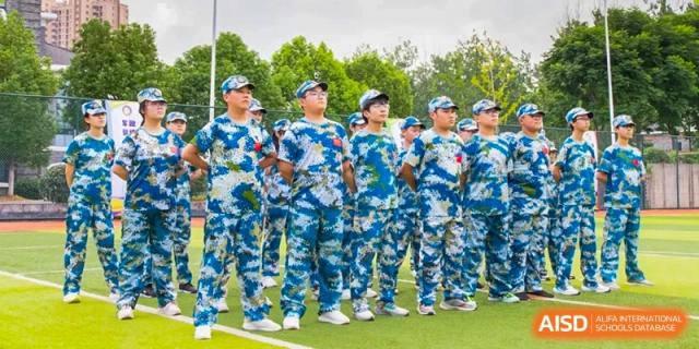 A group of students from Times College standing in formation, wearing blue and white camouflage military training uniforms.