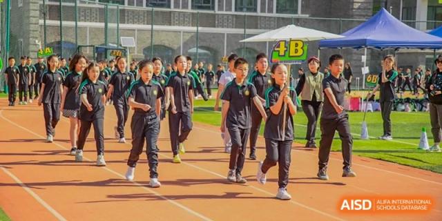 Students from Times College participating in a running race on an outdoor track.
