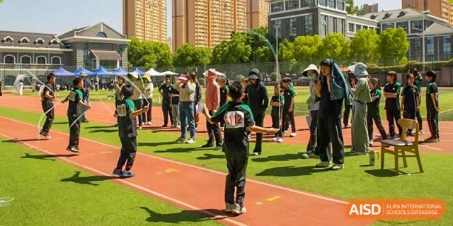 Students from Times College participating in a sports event, with one student standing on a running track.
