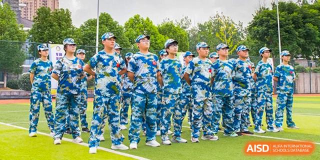 Students from Times College standing in formation, wearing blue and white camouflage military training uniforms.