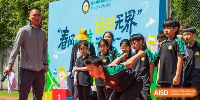 Students from Times College gathered at an outdoor event with colorful banners in the background.