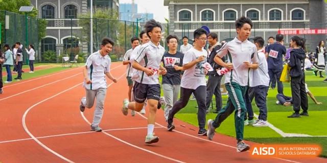Students from Times College running a race on an outdoor track.