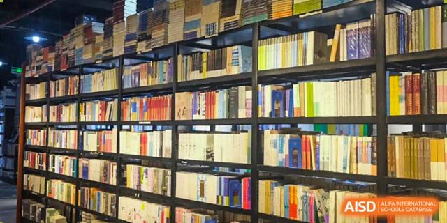 A wide shot of bookshelves filled with books in the UWC Changshu China library.