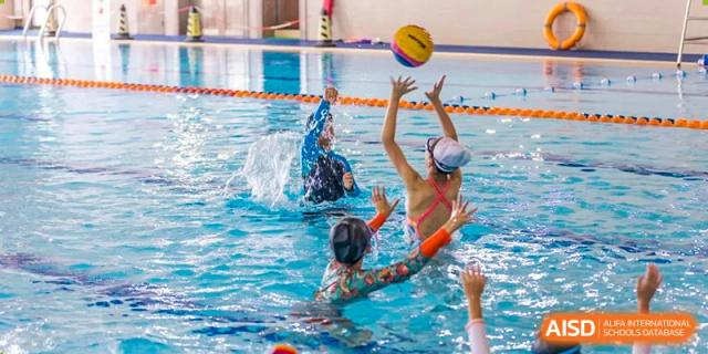 UWC Changshu China students playing water polo in a swimming pool.