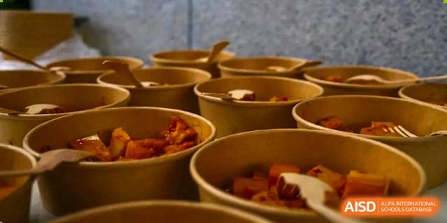 Several UWC Changshu China students' meals in brown takeaway containers.