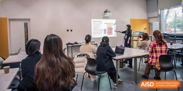 Western Academy of Beijing students listen to a teacher during a classroom presentation.