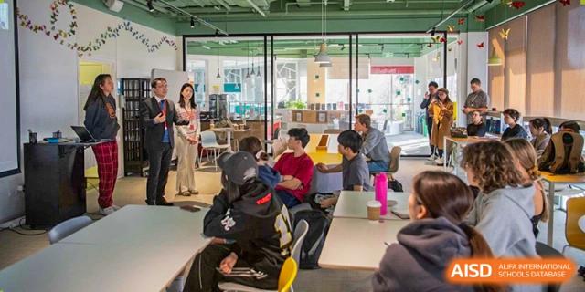 Western Academy of Beijing students and a teacher gather in a group for a classroom activity.