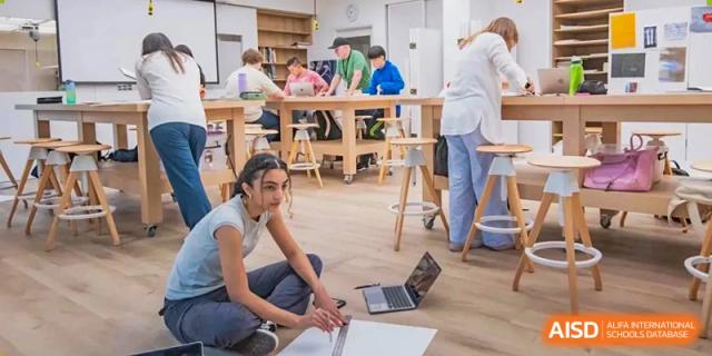 Western Academy of Beijing students work on laptops in a collaborative, open-plan space.