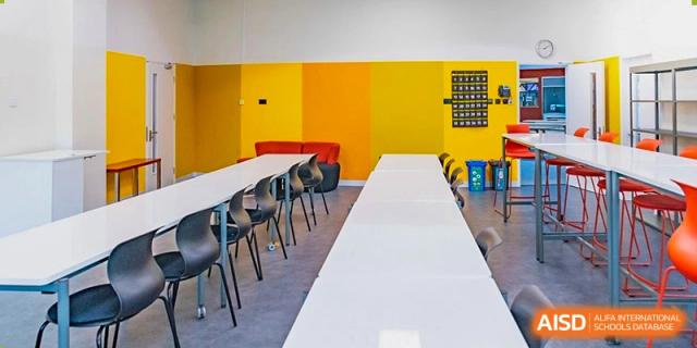 An empty Western Academy of Beijing classroom with a long table and colorful walls.
