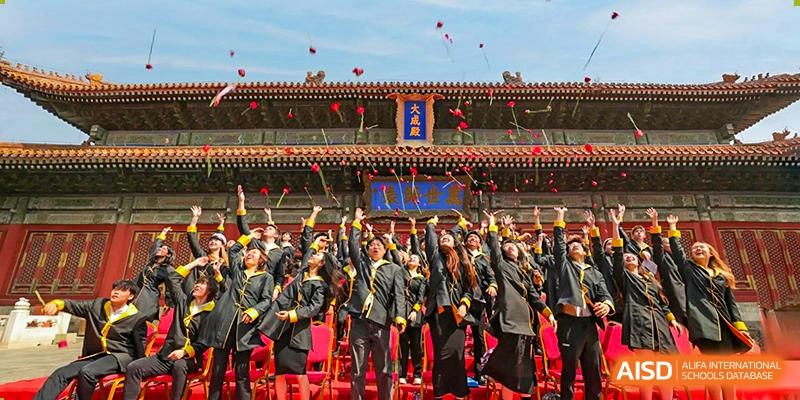 A large group of Western Academy of Beijing students and adults in a courtyard, posing in front of a traditional Chinese building.