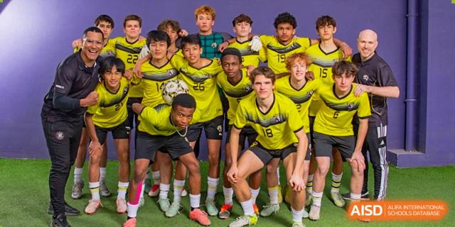 A Western Academy of Beijing sports team posing for a group photo in their yellow jerseys.