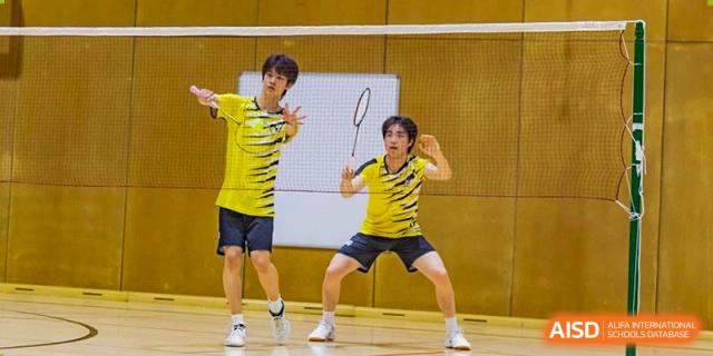 Western Academy of Beijing students playing badminton in a gymnasium.