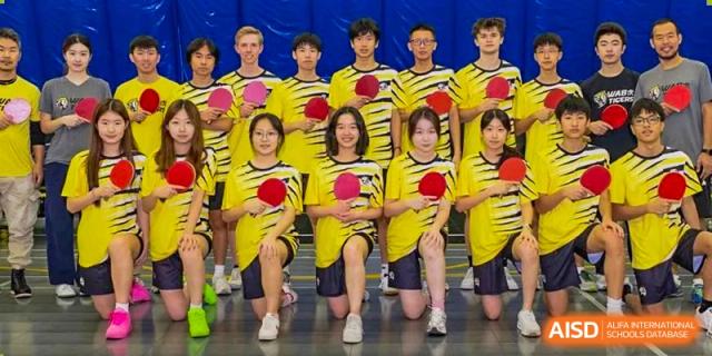 A Western Academy of Beijing sports team posing for a group photo on a field.