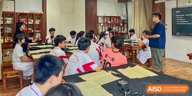 Students in a classroom are engaged in a group activity around a large table at the Xishan School of The High School Affiliated to Renmin University of China.