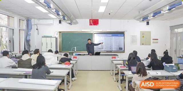 A teacher is seen instructing students in a classroom with a projector screen at the Xishan School of The High School Affiliated to Renmin University of China.