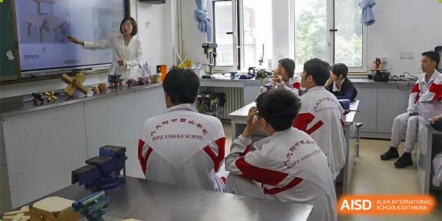 A teacher is providing individual instruction to a student in a classroom at the Xishan School of The High School Affiliated to Renmin University of China.