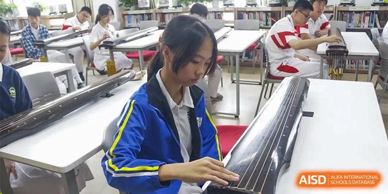 A close-up of a student playing a guzheng at Xishan School of The High School Affiliated to Renmin University of China.
