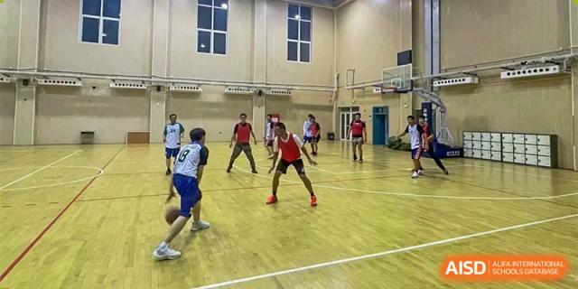 Xishan School of The High School Affiliated to Renmin University of China students playing basketball in a gymnasium.