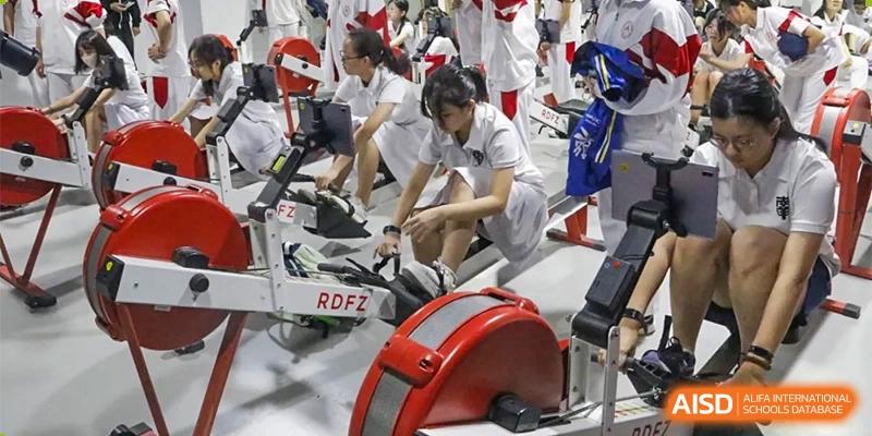 Xishan School of The High School Affiliated to Renmin University of China students exercising with rowing machines indoors.