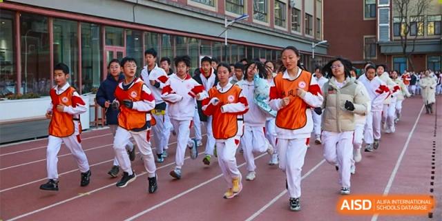 A group of Xishan School of The High School Affiliated to Renmin University of China students running on a track.